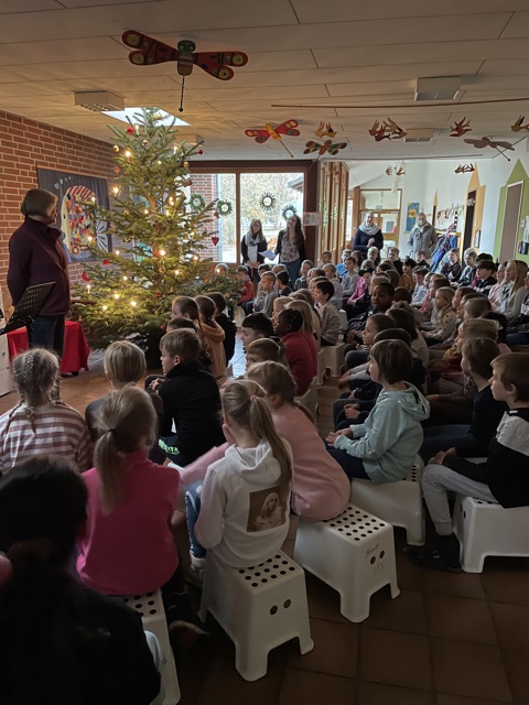 Kinder auf den Hockern um den Weihnachtsbaum